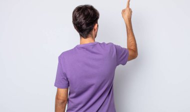 Genç, yakışıklı İspanyol adam dikiz aynasında duran ve objeye işaret eden.