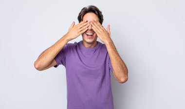 Genç, yakışıklı İspanyol adam gülümsüyor ve mutlu hissediyor, iki eliyle gözlerini kapatıyor ve inanılmaz bir sürpriz bekliyor.