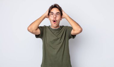 Genç, yakışıklı, İspanyol bir adam heyecanlı ve şaşırmış görünüyor. İki eli başında, ağzı açık, kendini şanslı bir kazanan gibi hissediyor.