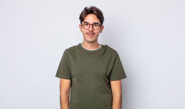 Genç, yakışıklı İspanyol adam pozitif ve kendinden emin gülümsüyor. Tatmin olmuş, arkadaş canlısı ve mutlu görünüyor.