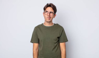 Genç, yakışıklı İspanyol bir adam kafası karışmış ve şaşkın görünüyor. Bir sorunu çözmeye çalışıyor ya da düşünüyor.