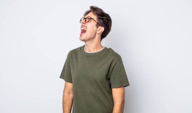 Genç, yakışıklı İspanyol adam öfkeyle bağırıyor, agresif bir şekilde bağırıyor, stresli ve sinirli görünüyor.