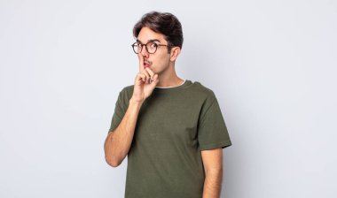 Genç, yakışıklı, İspanyol bir adam sessizlik ve sessizlik istiyor. Parmağını ağzının önüne uzatıp 