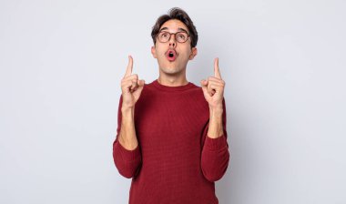 Genç, yakışıklı İspanyol bir adam korkuyla ve ağzı açık bir şekilde şaşkın ve şaşkın bir bakışla yukarı bakıyor.