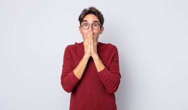 Genç, yakışıklı İspanyol adam mutlu ve heyecanlı, şaşırmış ve hayrete düşmüş elleriyle ağzını kapatmış, tatlı bir ifadeyle kıkırıyor.