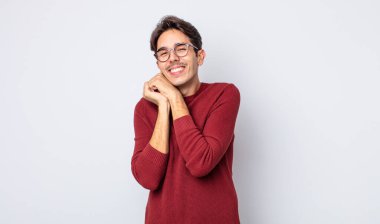 Genç, yakışıklı, İspanyol bir adam aşık ve sevimli görünüyor. Sevimli ve mutlu. Romantik bir şekilde gülümsüyor.