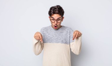 Genç, yakışıklı, İspanyol bir adam şok olmuş, ağzı açık ve şaşırmış hissediyor. İnançsızlık ve şaşkınlık içinde bakıyor ve onu işaret ediyor.