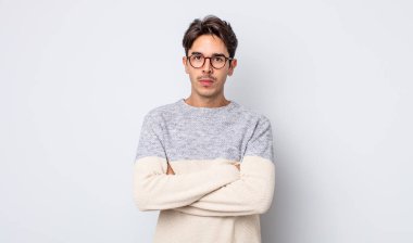 Genç, yakışıklı, İspanyol bir adam hayal kırıklığına uğramış ve hayal kırıklığına uğramış hissediyor. Ciddi görünüyor, kızgın ve kollarını kavuşturmuş.