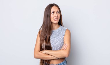 Hispanik güzel kadın şüpheye düşüyor ya da düşünüyor, dudağını ısırıyor ve kendini güvensiz ve gergin hissediyor, kenarda yer arıyor.