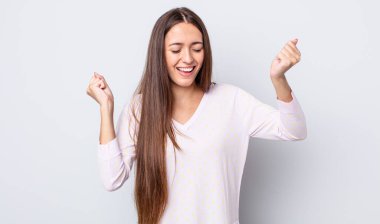 İspanyol güzel kadın son derece mutlu ve şaşırmış görünüyor, başarıyı kutluyor, bağırıyor ve zıplıyor.