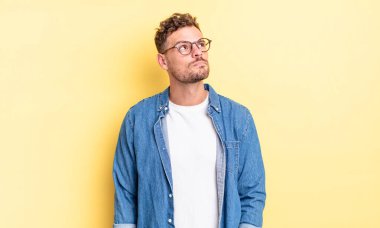 Endişeli, kafası karışık, cahil bir ifadeyle genç, yakışıklı İspanyol adam, kopya alanı arıyor, şüpheci