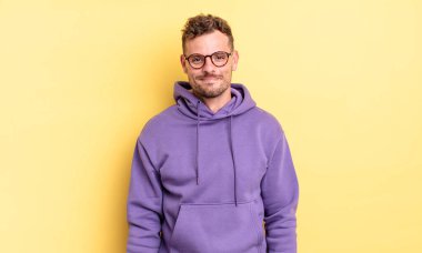 Genç, yakışıklı İspanyol adam pozitif ve kendinden emin gülümsüyor. Tatmin olmuş, arkadaş canlısı ve mutlu görünüyor.