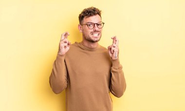 Genç yakışıklı İspanyol adam endişeyle dua ediyor ve endişeli bir bakışla iyi şanslar diliyor.