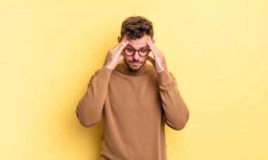 Genç, yakışıklı, İspanyol bir adam stresli ve hayal kırıklığına uğramış görünüyor. Baskı altında, baş ağrısı ve sorunlarıyla çalışıyor.