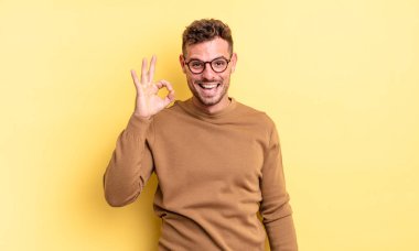 Genç, yakışıklı İspanyol adam kendini başarılı ve tatmin olmuş hissediyor ağzı açık gülümsüyor, elle imza atıyor.