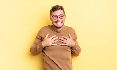 Genç yakışıklı İspanyol adam mutlu, şaşırmış, gururlu ve heyecanlı görünüyor.