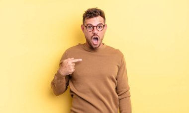 Genç, yakışıklı, şaşkın ve şaşkın bakan, ağzı açık, kendini işaret eden bir İspanyol.