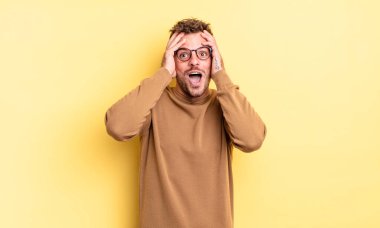 Genç, yakışıklı, İspanyol bir adam el ele tutuşuyor, ağzı açık, son derece şanslı, şaşırmış, heyecanlı ve mutlu.