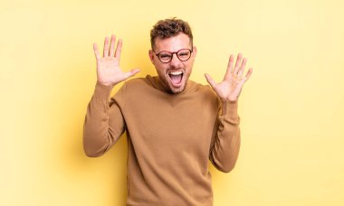 Genç, yakışıklı İspanyol adam panik ya da öfke içinde bağırıyor. Şok olmuş, korkmuş ya da öfkeli. Elleri başının yanında.