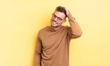 Genç, yakışıklı İspanyol adam neşeli ve sıradan bir şekilde gülümsüyor. Olumlu, mutlu ve kendinden emin bir bakışla yumruk yumruğa.