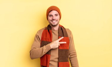 Genç, yakışıklı İspanyol adam kendini mutlu, pozitif ve başarılı hissediyor. Göğsünde el yapımı V şekli var. Zafer ya da barış gösteriyor.