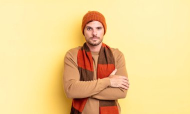 Genç, yakışıklı, İspanyol bir adam hayal kırıklığına uğramış ve hayal kırıklığına uğramış hissediyor. Ciddi görünüyor, kızgın ve kollarını kavuşturmuş.