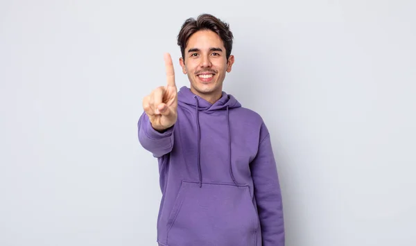 Joven Hombre Hispano Guapo Sonriendo Buscando Amigable Mostrando Número Uno — Foto de Stock