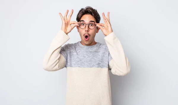 Joven Hombre Hispano Guapo Sintiéndose Sorprendido Sorprendido Sorprendido Sosteniendo Gafas — Foto de Stock