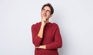 Genç, yakışıklı İspanyol adam düşünüyor, kuşkulu ve şaşkın hissediyor, farklı seçenekleri var, hangi kararı vereceğini merak ediyor.