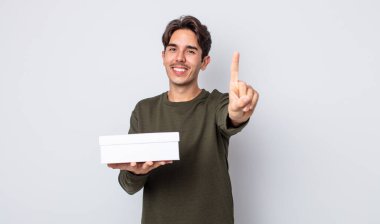 Genç İspanyol adam gururla gülümsüyor ve kendinden emin bir numara oluyor. beyaz kutu kavramı