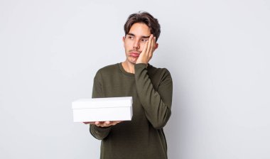 Genç İspanyol bir adam bıkkın, bezgin ve uykulu hissediyor. beyaz kutu kavramı