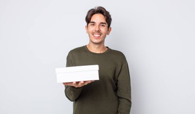 Genç İspanyol adam mutlu ve hoş bir şekilde şaşırmış görünüyor. beyaz kutu kavramı