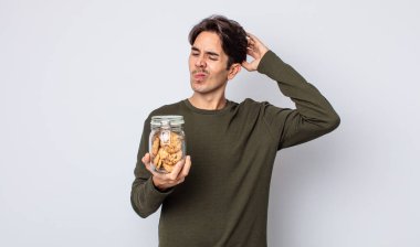 Genç İspanyol adam mutlu bir şekilde gülümsüyor ve hayal kuruyor ya da şüphe ediyor. kurabiye konsepti