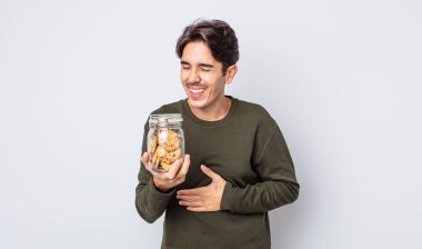 Genç İspanyol bir adam komik bir şakaya yüksek sesle gülüyor. kurabiye konsepti