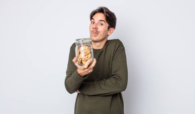 Genç İspanyol adam omuz silkiyor, kafası karışık ve kararsız. kurabiye konsepti