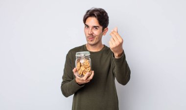 Genç İspanyol adam kapiş ya da para hareketi yapıyor, sana ödemeni söylüyor. kurabiye konsepti