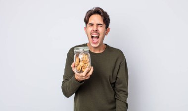 Genç İspanyol adam agresif bir şekilde bağırıyor, çok kızgın görünüyor. kurabiye konsepti