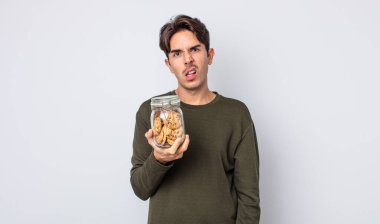 Genç İspanyol adam şaşkın ve şaşkın hissediyor. kurabiye konsepti