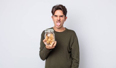 Genç İspanyol adam iğreniyor, sinirleniyor ve dili dışarı çıkıyor. kurabiye konsepti
