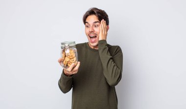 Genç İspanyol adam mutlu, heyecanlı ve şaşırmış hissediyor. kurabiye konsepti