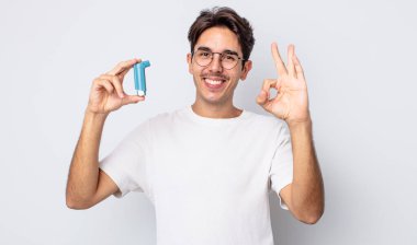 Genç İspanyol adam kendini mutlu hissediyor, iyi bir jestle onaylıyor. astım konsepti