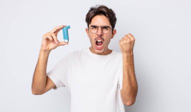 Genç İspanyol adam sinirli bir ifadeyle agresif bir şekilde bağırıyor. astım konsepti