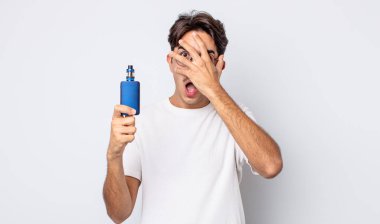 Genç İspanyol bir adam şok olmuş, korkmuş ya da korkmuş görünüyor. Yüzü elle kapatılmış. duman buharlaştırıcı kavramı