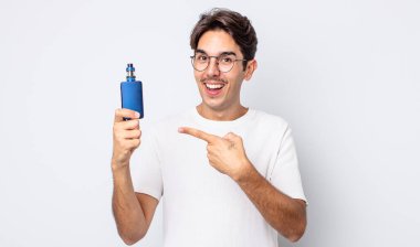 Genç İspanyol adam heyecanlı ve şaşırmış görünüyor. duman buharlaştırıcı kavramı