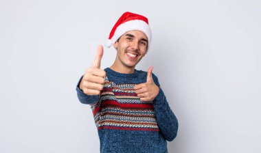 Genç İspanyol adam gururlu, olumlu bir şekilde gülümsüyor. Yeni yıl ve Noel konsepti