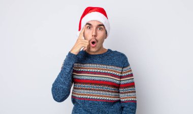 Genç İspanyol adam şaşırmış görünüyor, yeni bir düşünce, fikir ya da konsept keşfediyor. Yeni yıl ve Noel konsepti