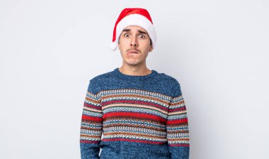 Genç İspanyol adam şaşkın ve şaşkın görünüyor. Yeni yıl ve Noel konsepti