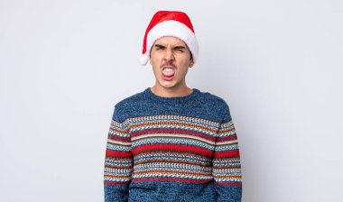 Genç İspanyol adam iğreniyor, sinirleniyor ve dili dışarı çıkıyor. Yeni yıl ve Noel konsepti
