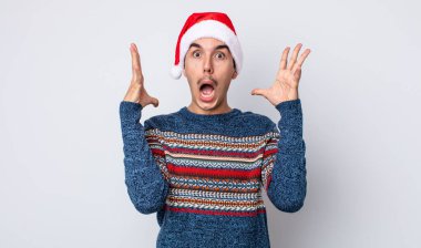 Genç İspanyol adam ellerini havaya kaldırarak çığlık atıyor. Yeni yıl ve Noel konsepti