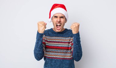 Genç İspanyol adam sinirli bir ifadeyle agresif bir şekilde bağırıyor. Yeni yıl ve Noel konsepti